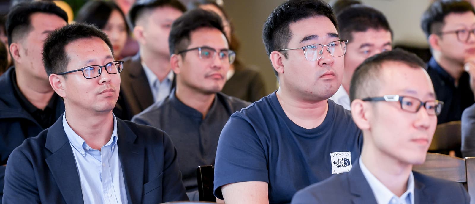 企业管理研讨会现场，与会者专注听取流程优化方案